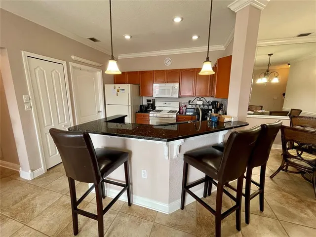 a kitchen with a dining table chairs sink and cabinets