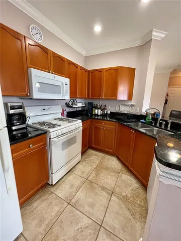 a kitchen with stainless steel appliances granite countertop a sink a stove a microwave a counter top space and cabinets