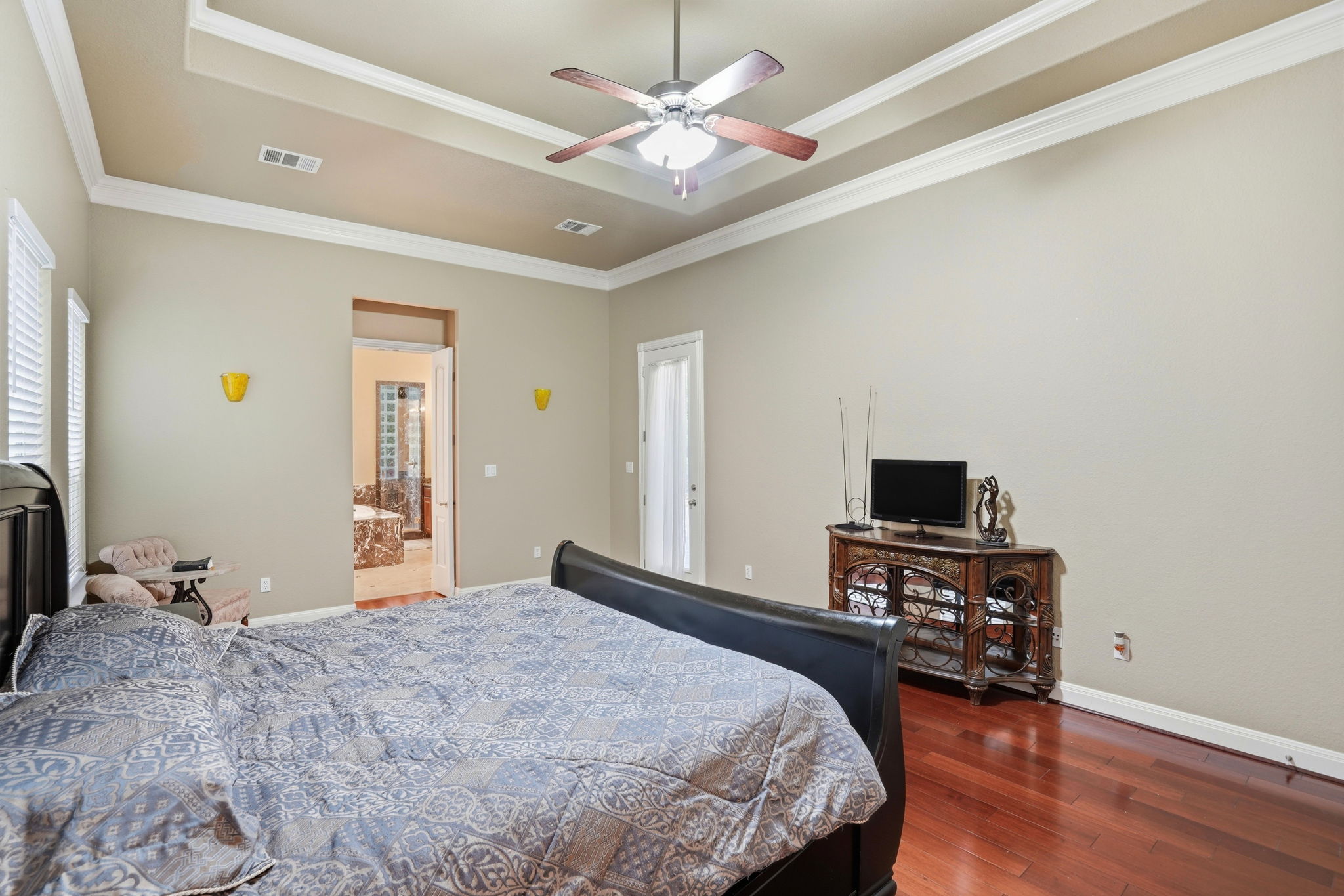 222 Vailco Lane Austin, TX 78738 - Photo 30 of 39 Spacious room featuring wood-finish flooring, a tray ceiling with crown molding, and a ceiling fan