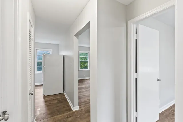 a view of a hallway with wooden floor and closet