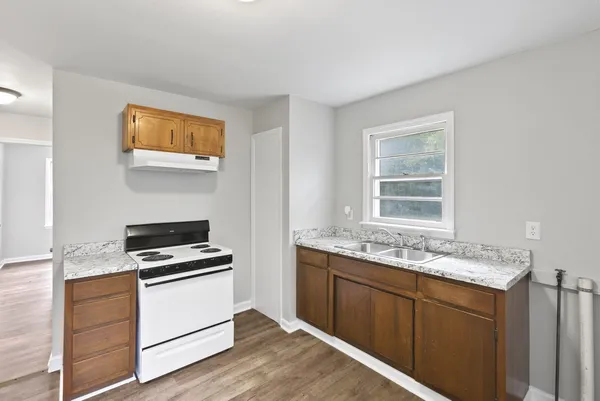 a kitchen with a stove cabinets and wooden floor