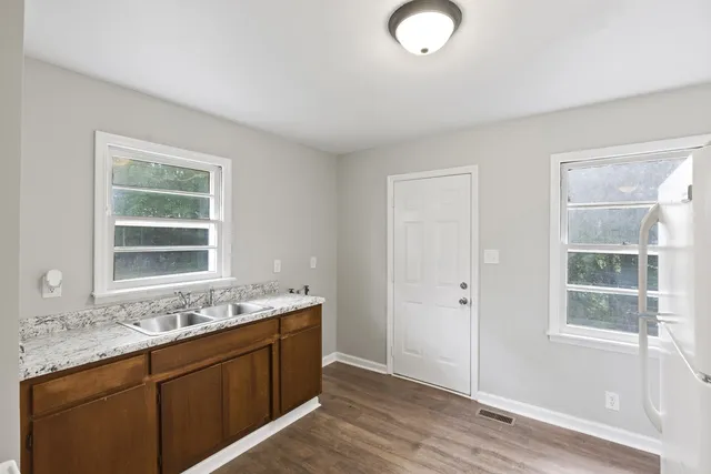 a bathroom with a granite countertop sink mirror and window