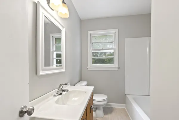 a bathroom with a sink a toilet and a mirror
