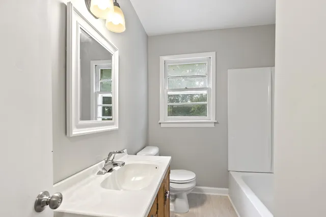 a bathroom with a sink a toilet and a mirror