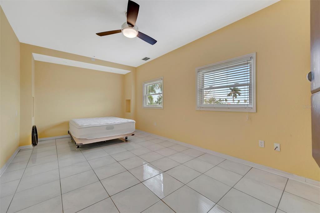 614 Norton Street Longboat Key, FL 34228 - Photo 58 of 71 a living room with a baby crib furniture and a ceiling fan