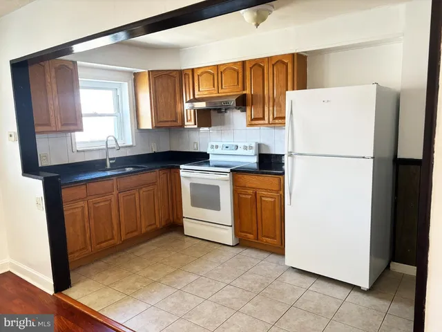 a kitchen with a sink a stove a refrigerator and cabinets