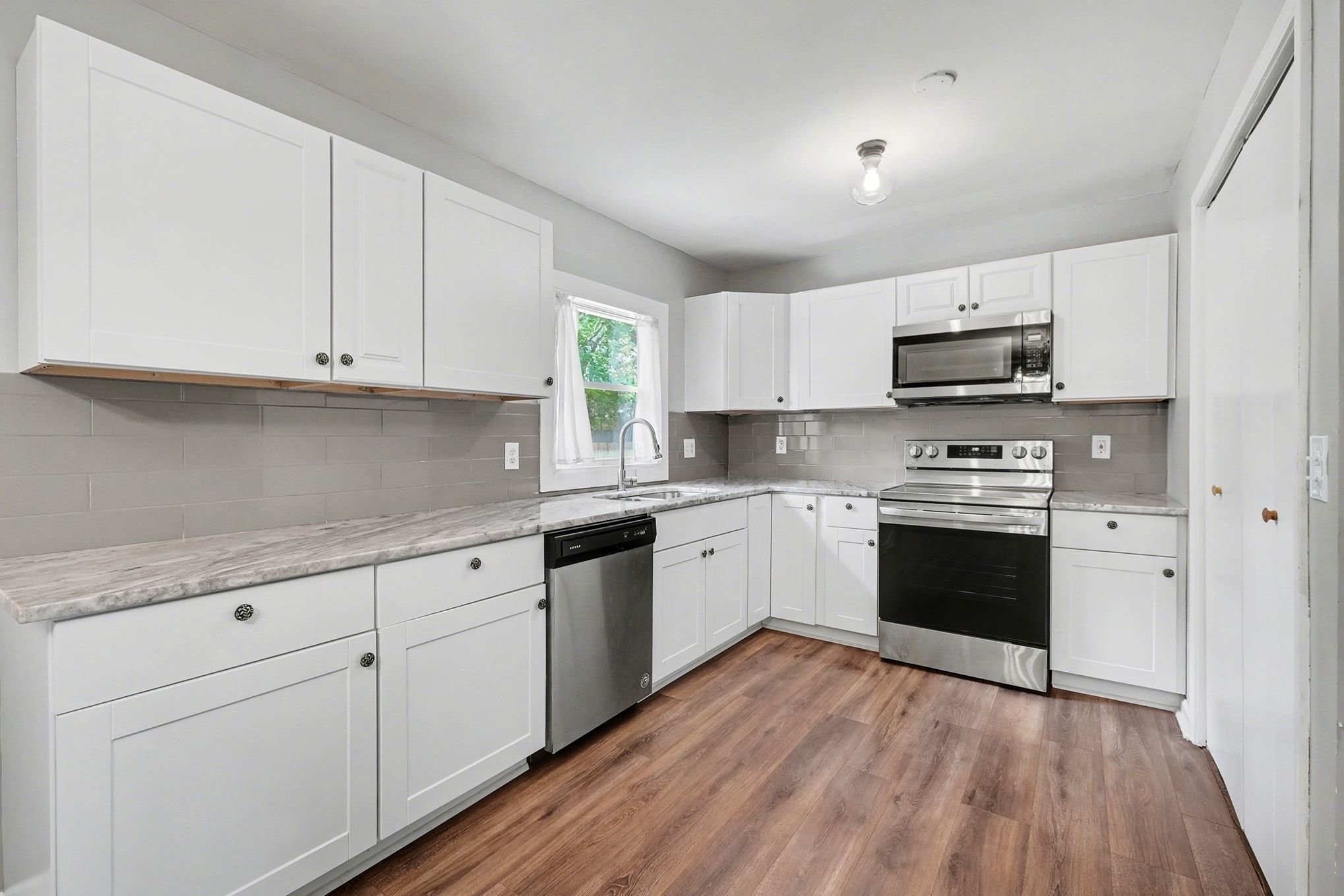 1214 Rutherford Street Murfreesboro, TN 37130 - Photo 12 of 32 a kitchen with granite countertop a sink cabinets and stainless steel appliances