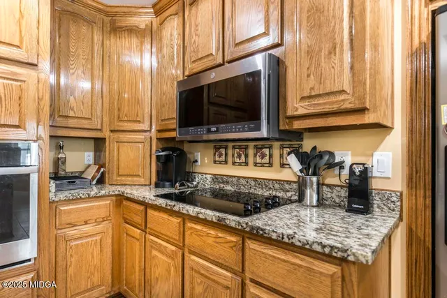 a kitchen with stainless steel appliances granite countertop a sink and a microwave