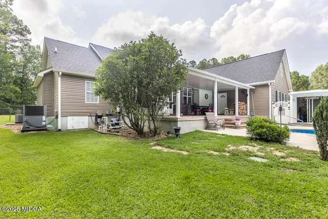 a view of a house with a backyard and a patio