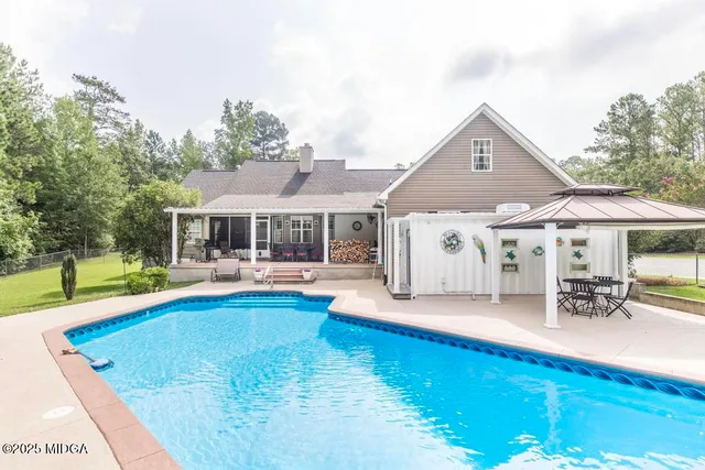 a front view of house with swimming pool yard and outdoor seating