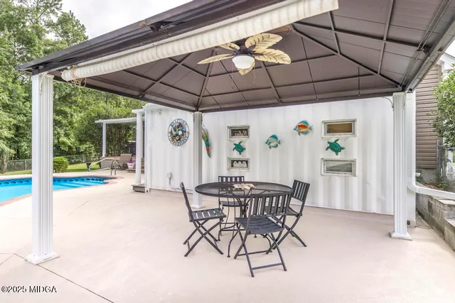 a patio with a table and chairs under an umbrella