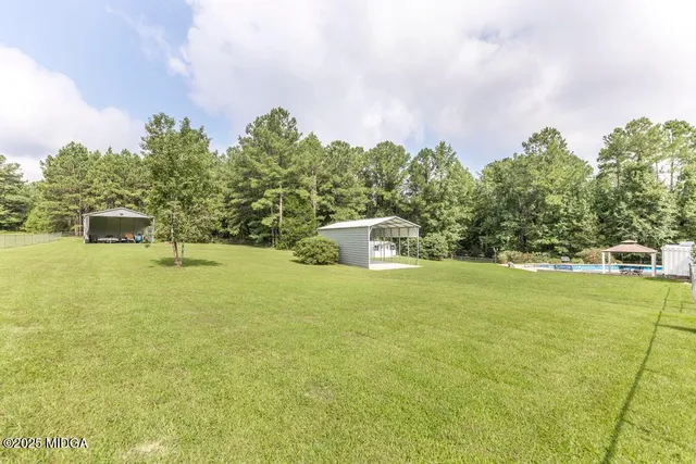 a white house with a big yard and large trees