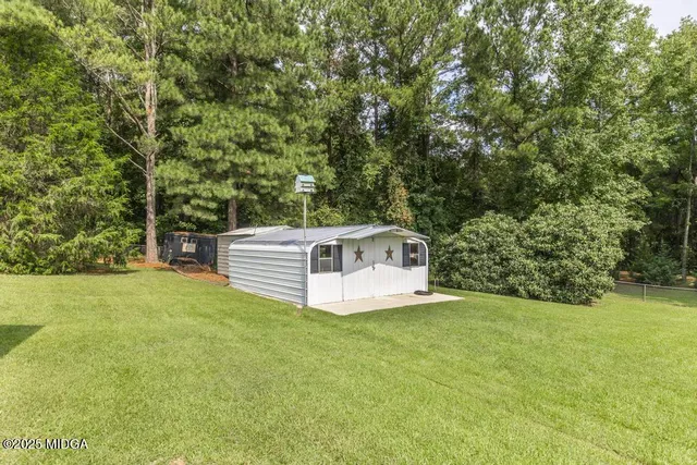 a view of a house with a backyard and a patio