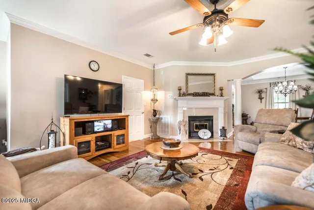 a living room with furniture a flat screen tv and a fireplace