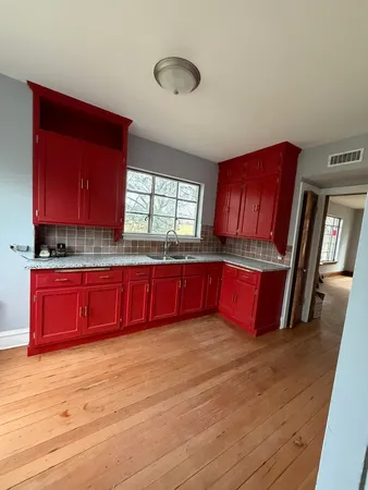 a kitchen with stainless steel appliances kitchen island granite countertop wooden cabinets sink and window