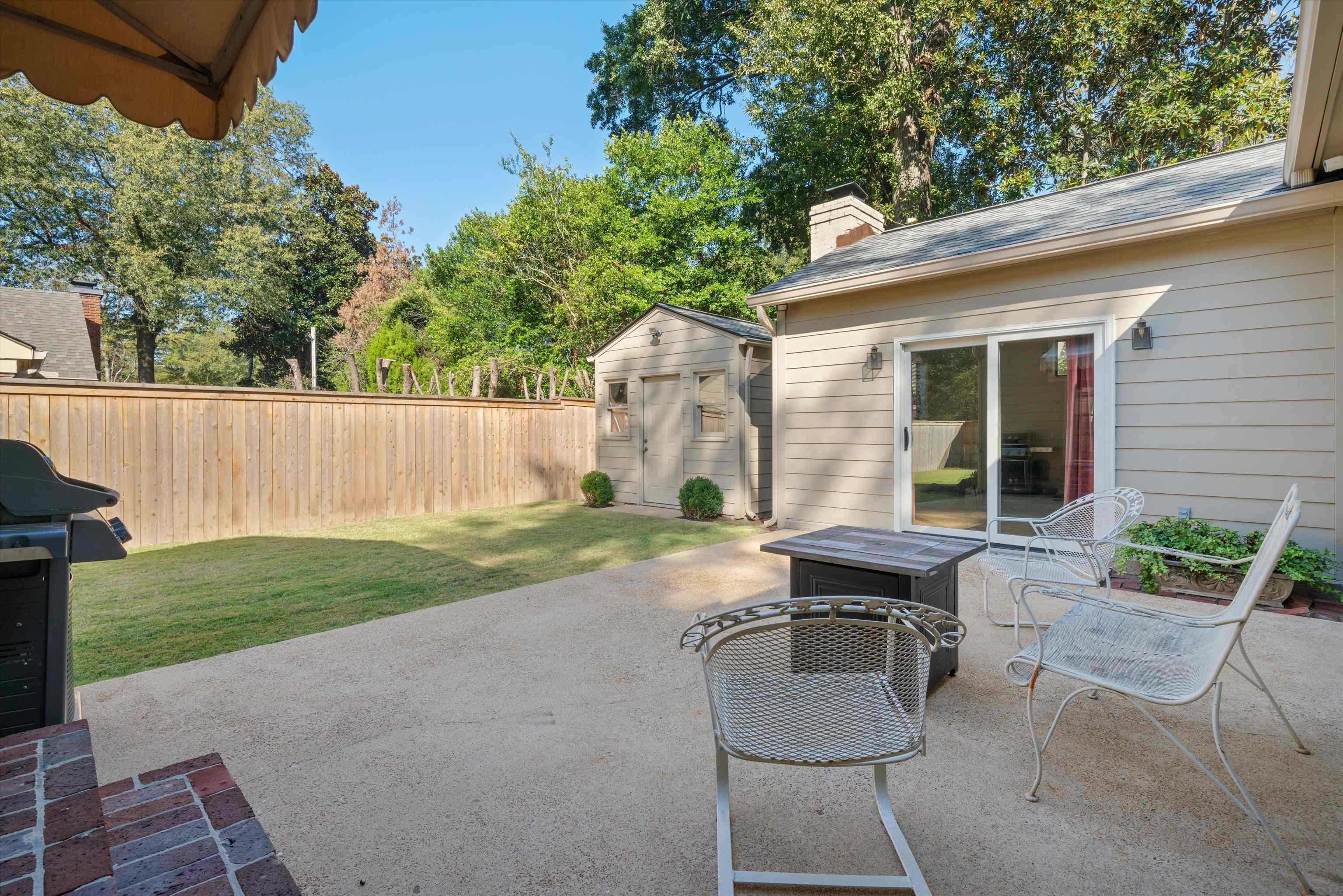567 South Yates Road Memphis, TN 38120 - Photo 17 of 20 a view of a patio with chairs potted plants and a large tree