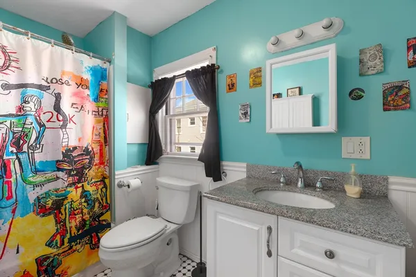 a bathroom with a granite countertop toilet sink and mirror