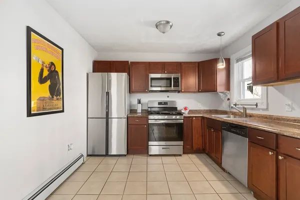 a kitchen with stainless steel appliances granite countertop a refrigerator sink and stove
