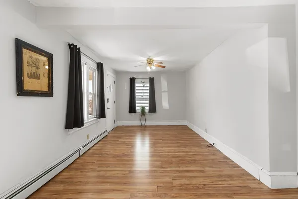 a view of an empty room with wooden floor