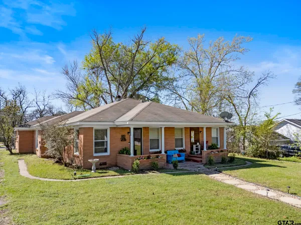 a front view of a house with swimming pool and garden