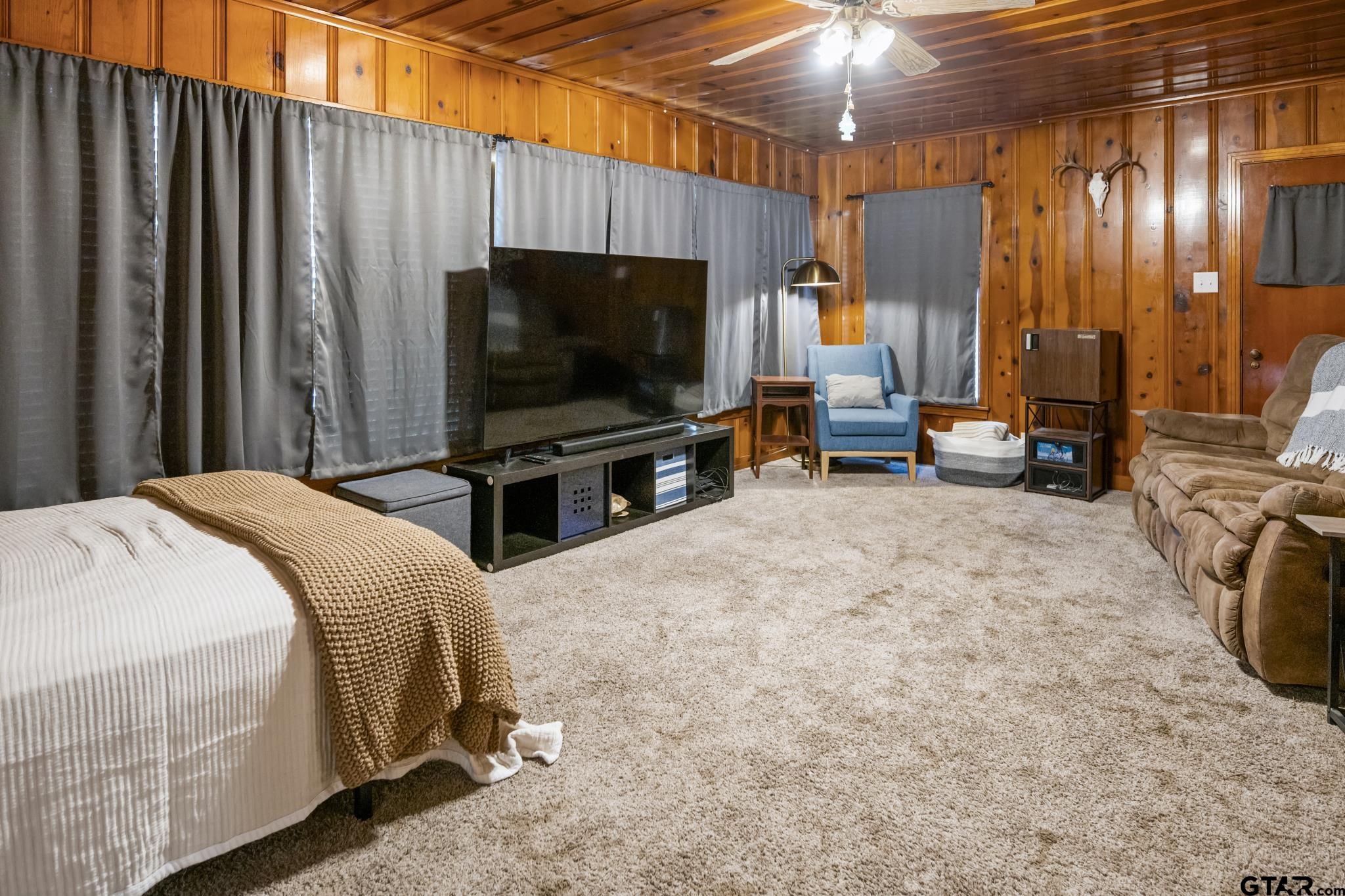 290 Lynch Street Hawkins, TX 75765 - Photo 20 of 36 a bedroom with a bed a flat screen tv and a chandelier