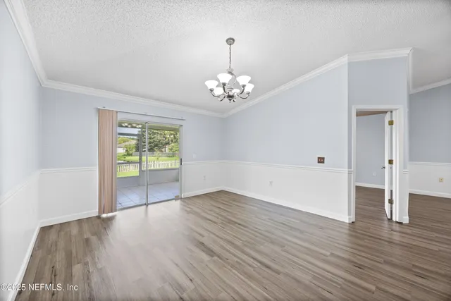 an empty room with wooden floor and window