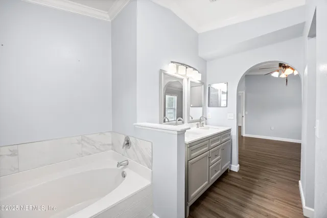 a spacious bathroom with a bathtub sink and mirror