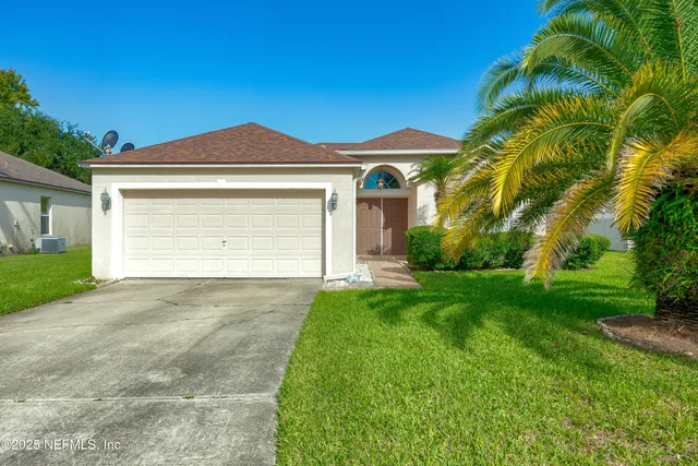 a front view of a house with a yard and garage