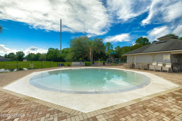 a view of a swimming pool is middle in the backyard