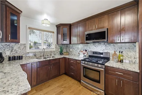 a kitchen with granite countertop stainless steel appliances sink and cabinets