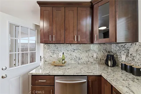 a kitchen with granite countertop wooden cabinets and stainless steel appliances