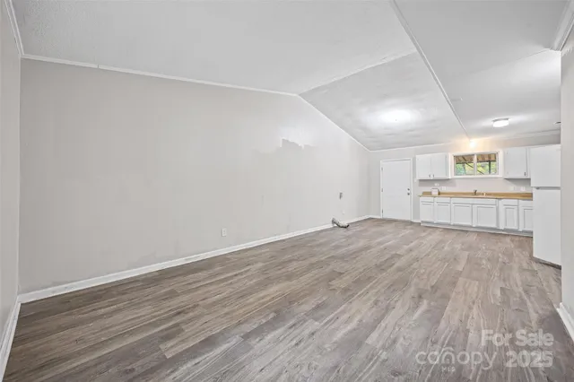wooden floor in an empty room with a kitchen