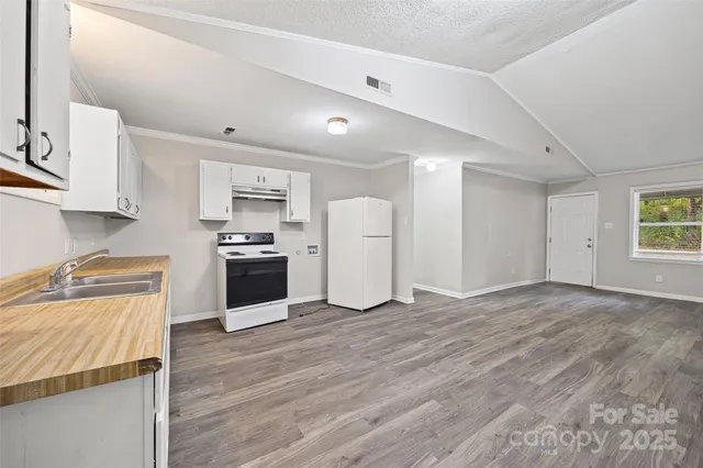 a kitchen with granite countertop a sink cabinets and stainless steel appliances