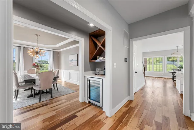 a kitchen with cabinets a sink dishwasher a stove and a dining table with wooden floor