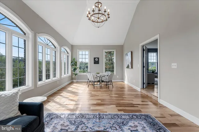 a dining room with furniture a chandelier and wooden floor