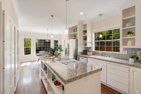a kitchen with stainless steel appliances granite countertop a refrigerator a stove and a sink