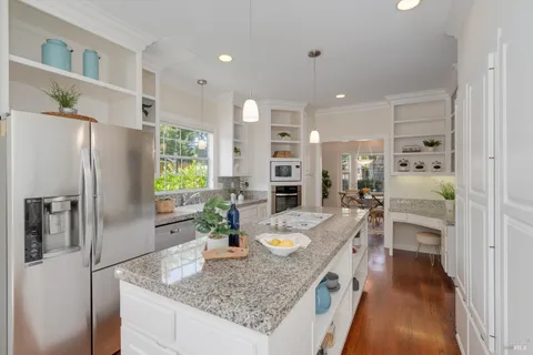a kitchen with granite countertop a sink stainless steel appliances and cabinets