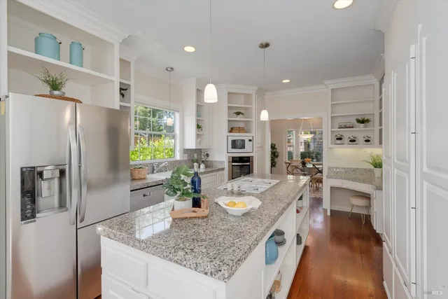 a kitchen with granite countertop a sink stainless steel appliances and cabinets