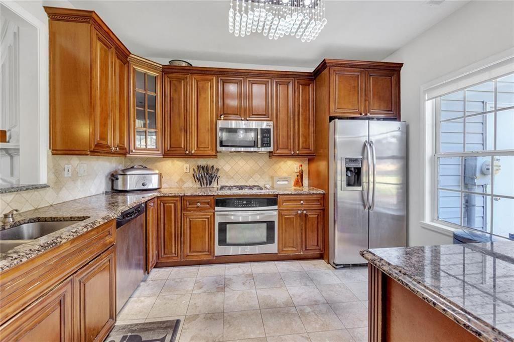 13300 Morris Road, Unit 4 Alpharetta, GA 30004 - Photo 11 of 36 a kitchen with stainless steel appliances granite countertop a refrigerator stove and sink