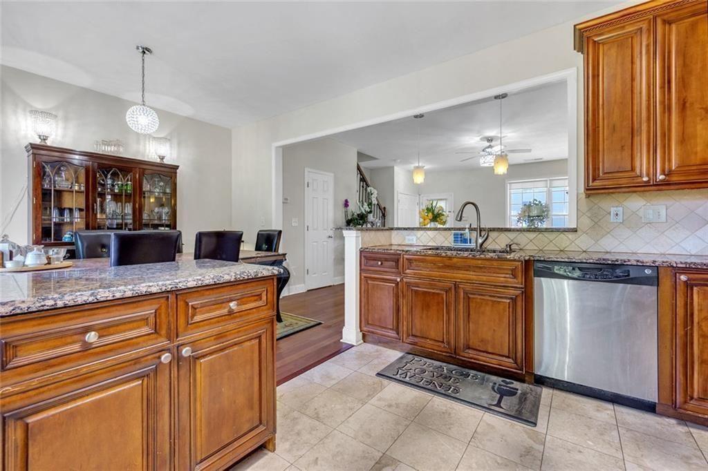 13300 Morris Road, Unit 4 Alpharetta, GA 30004 - Photo 12 of 36 a large kitchen with granite countertop a sink and dishwasher a stove with wooden cabinets
