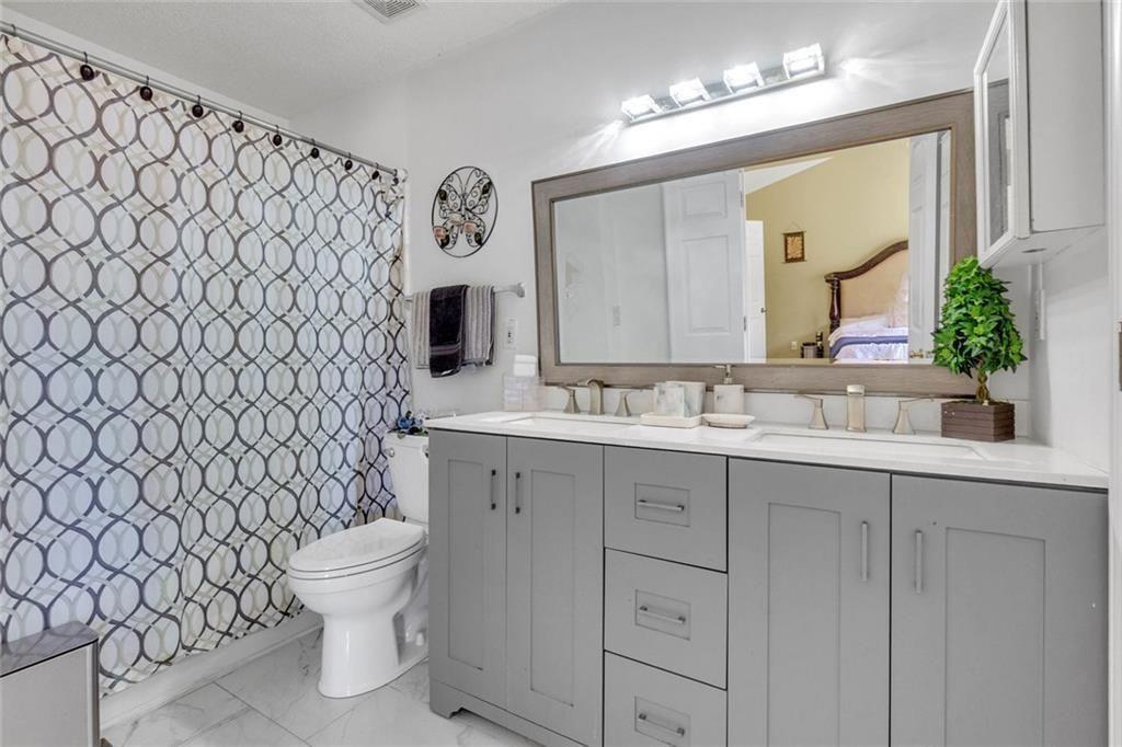 13300 Morris Road, Unit 4 Alpharetta, GA 30004 - Photo 19 of 36 a bathroom with a sink mirror and toilet