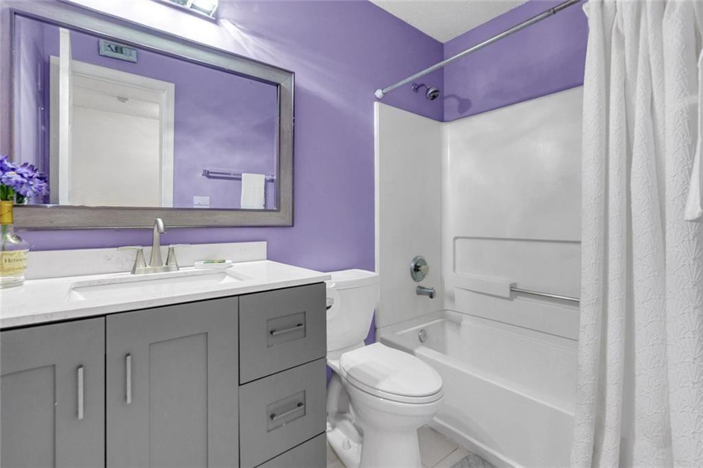 13300 Morris Road, Unit 4 Alpharetta, GA 30004 - Photo 20 of 36 a bathroom with a granite countertop sink toilet and shower