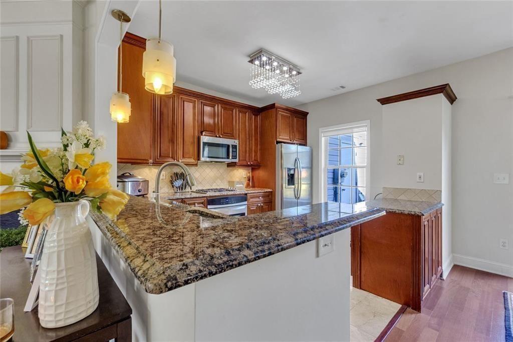 13300 Morris Road, Unit 4 Alpharetta, GA 30004 - Photo 10 of 36 a kitchen with granite countertop a sink a stove and cabinets