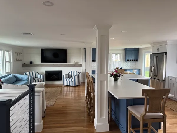 a view of a dining room with furniture a fireplace and wooden floor