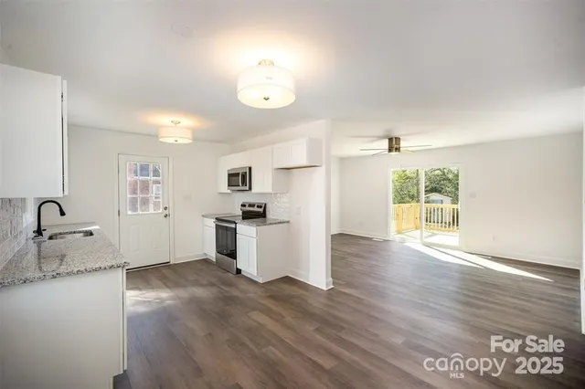 a view of a kitchen with wooden floor and electronic appliances
