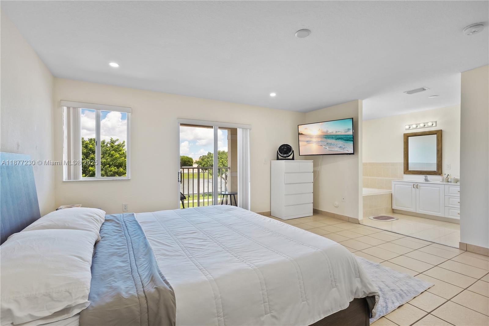 16256 Southwest 57th Lane Miami, FL 33193 - Photo 18 of 32 a bedroom with a large bed and a window