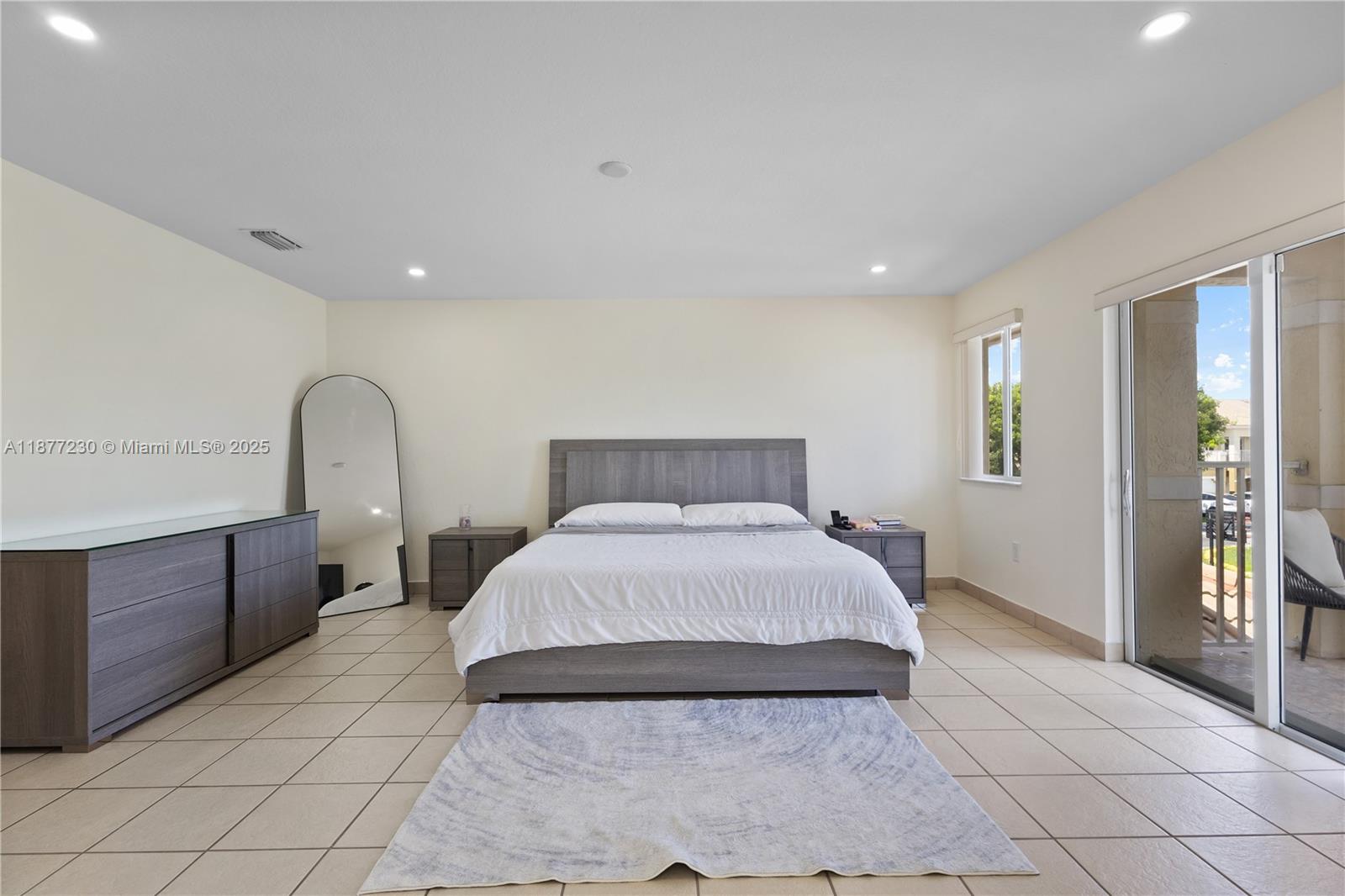 16256 Southwest 57th Lane Miami, FL 33193 - Photo 19 of 32 a bedroom with a large bed and a dresser