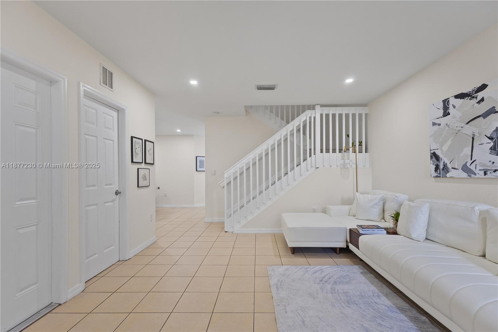 16256 Southwest 57th Lane Miami, FL 33193 - Photo 6 of 32 a living room with white walls furniture and a chandelier