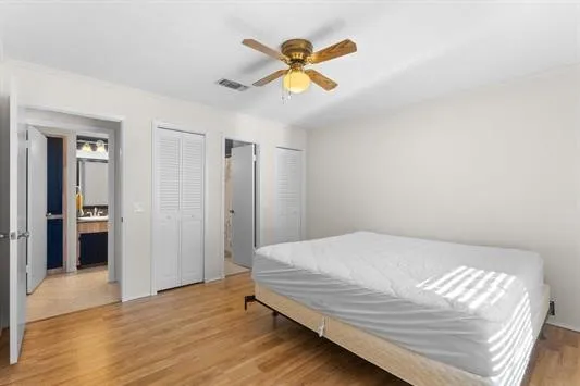 a bedroom with a bed and a ceiling fan