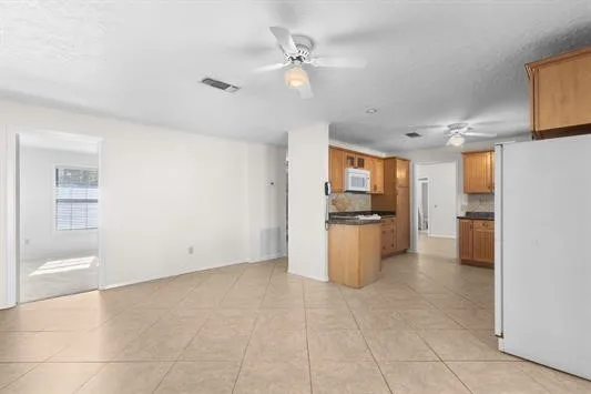 a view of a kitchen with a sink and a refrigerator